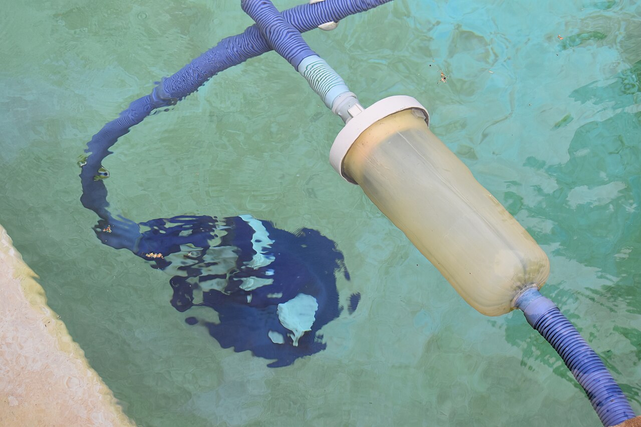 Automatic swimming pool cleaner operating underwater with hoses attached