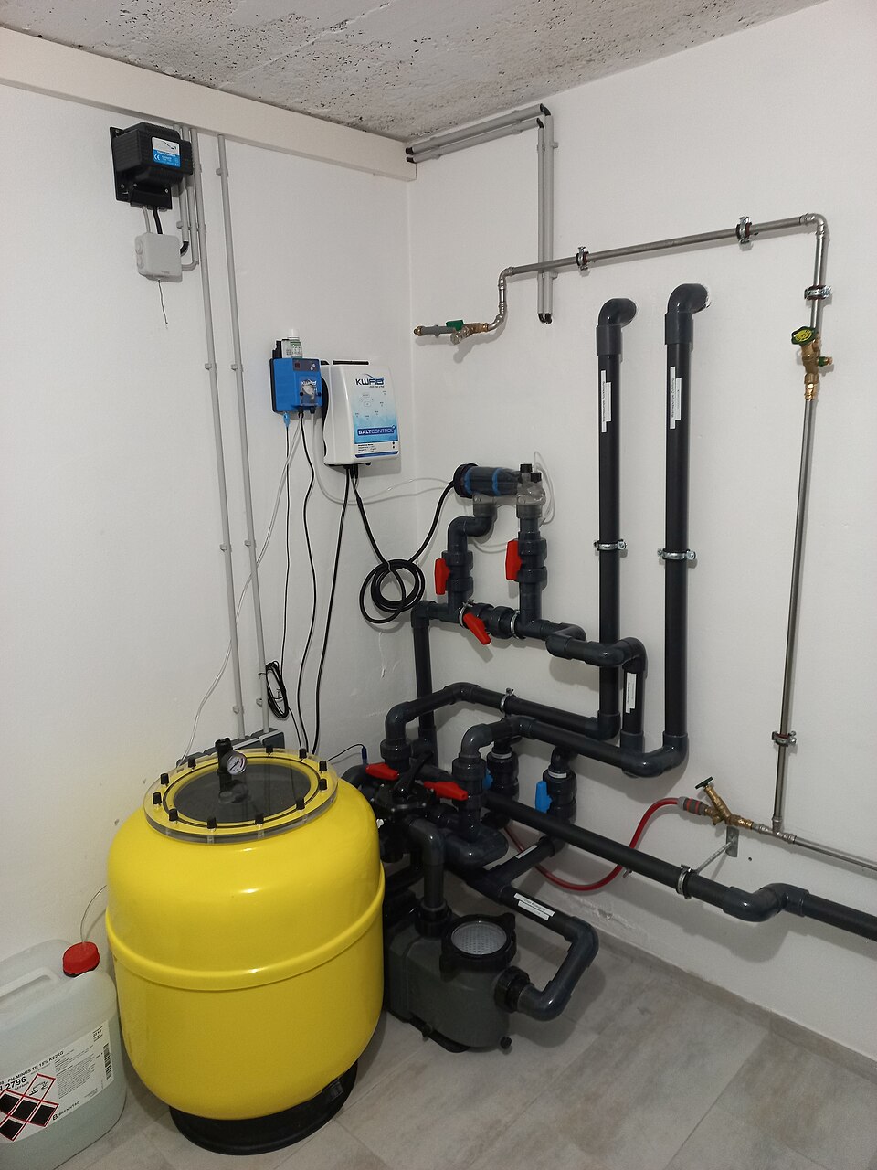 Swimming pool circulation pump with clear strainer lid, suction pipes and sand filter