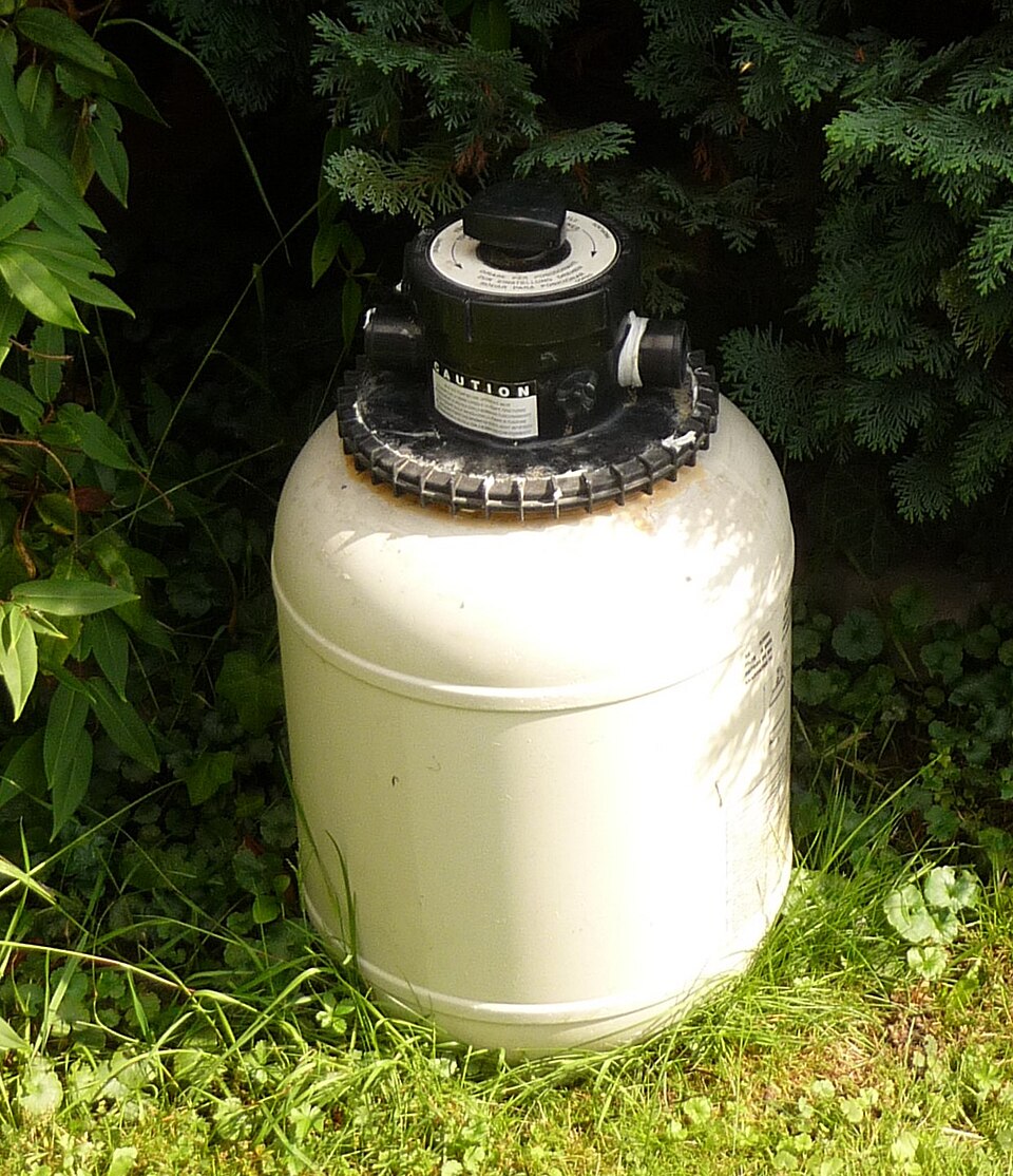 Residential sand pool filter tank with a top-mounted multiport valve; not a cartridge filter