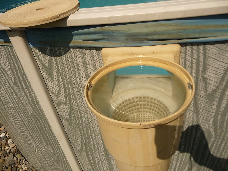 Above-ground swimming pool skimmer opening and basket on the pool wall